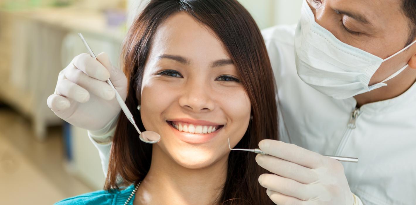 Smiling patient receiving a dental examination